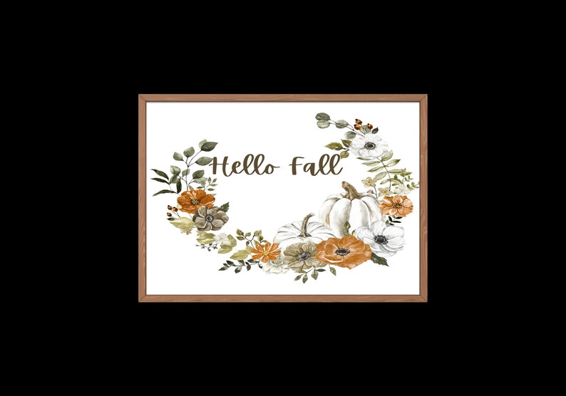 May include: A white framed print with a watercolor illustration of a floral wreath with pumpkins and the text "Hello Fall".