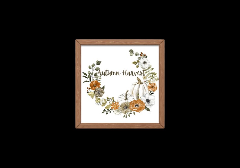 May include: Wooden framed print with a watercolour wreath of pumpkins, flowers, and foliage in orange, white, and green. The text "Autumn Harvest" is written in a script font.