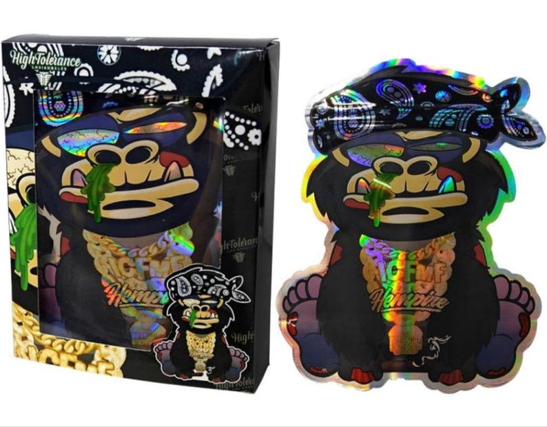 K&ouml;nnte beinhalten: Ein schwarzer und holografischer Gorilla-Aufkleber mit Bandana, goldener Kette und gr&uuml;nem Sabber. Der Aufkleber befindet sich in einer schwarzen Box mit den Worten "High Tolerance" und einer kleineren Gorilla-Grafik.