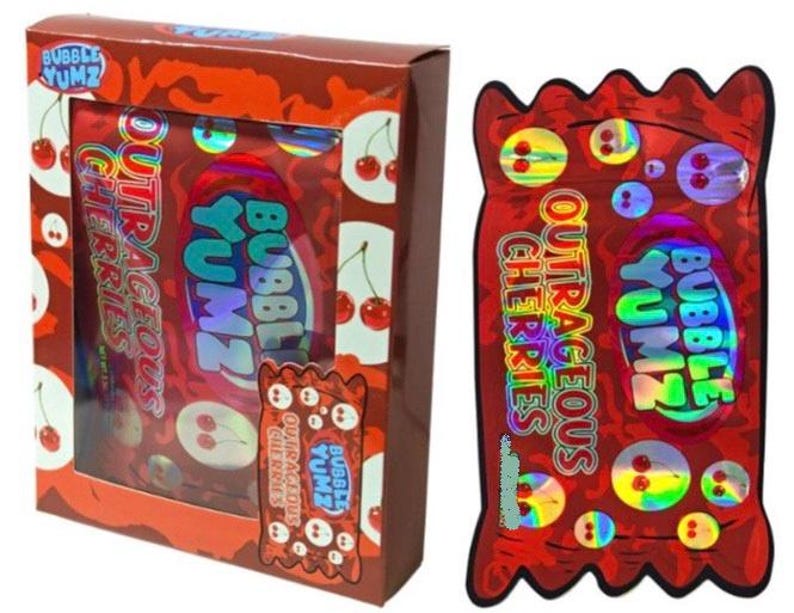 K&ouml;nnte beinhalten: Eine rote Schachtel mit Bubble Yumz Outrageous Cherries S&uuml;&szlig;igkeiten. Die Schachtel hat ein Fenster, das die S&uuml;&szlig;igkeiten im Inneren zeigt. Die Verpackung ist rot mit den Worten "Bubble Yumz" und "Outrageous Cherries" in einer Blasen-Schriftart.