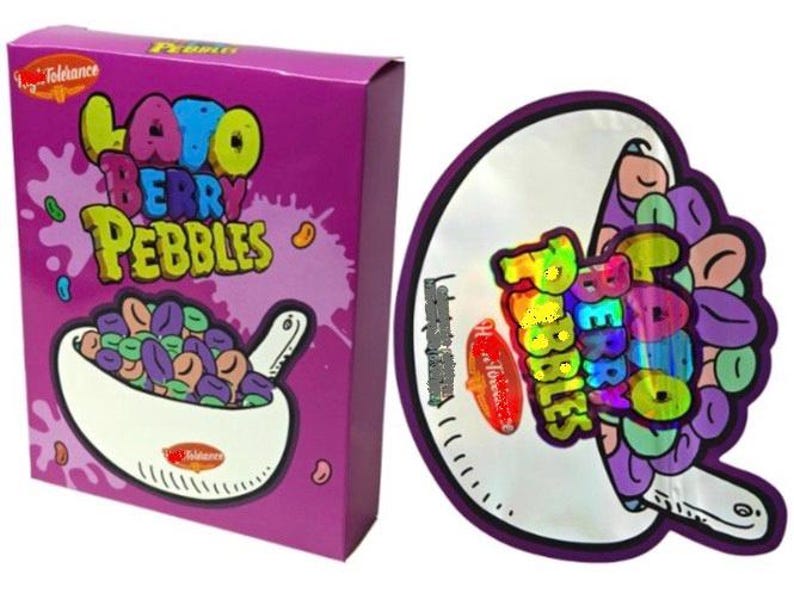 K&ouml;nnte beinhalten: Eine lila Schachtel und ein runder Aufkleber mit den Worten "Lato Berry Pebbles" in farbenfrohem Text. Die Schachtel zeigt eine Sch&uuml;ssel mit bunten Cerealien und der Aufkleber hat ein &auml;hnliches Design.