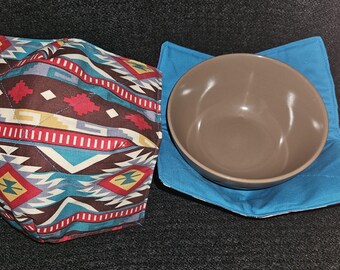 Peut inclure: Deux maniques matelassées avec un motif géométrique. L'une est bleue avec un bol brun à l'intérieur. L'autre est brune avec un motif géométrique turquoise, rouge et blanc.