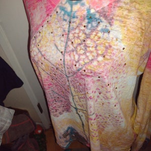 May include: A long-sleeved, pink, yellow, and blue shirt with a leaf design and gold-colored rhinestones.