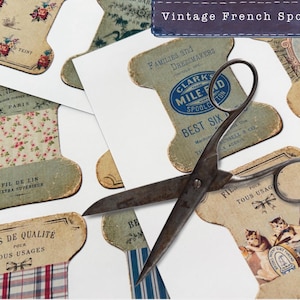 May include: An assortment of vintage French spools with various designs and text, including floral patterns and the words "FIL DE LIN." A pair of antique scissors rests on top of the spools. The text "Vintage French Spools" is at the top.