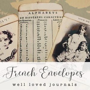 May include: Three vintage-style paper envelopes featuring sepia-toned imagery. The center envelope displays an alphabet chart with the text ALPHABETS EN DIFFERENS CARACTERE. The side envelopes feature black and white portraits of children.