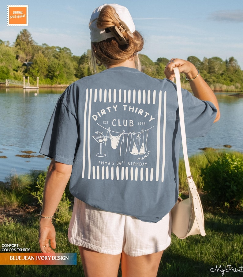 Puede incluir: Una camiseta azul vaquera con un gr&aacute;fico blanco que dice "Dirty Thirty Club" con un c&oacute;ctel, un bikini y el texto "Miami, FL". La camiseta tambi&eacute;n dice "Emma's 30th Birthday".
