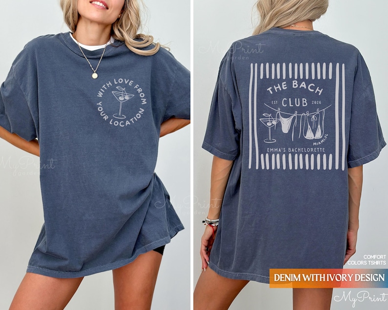 Puede incluir: Una camiseta azul denim con un gr&aacute;fico en la parte delantera que dice "With Love From Your Location" y una copa de c&oacute;ctel. La parte trasera de la camisa tiene un dise&ntilde;o que dice "The Bach Club" con un bikini y una copa de c&oacute;ctel.