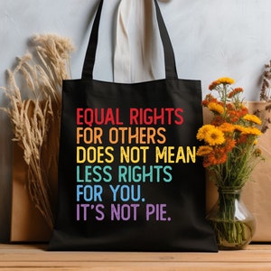 May include: Black tote bag with a rainbow-colored message that reads "EQUAL RIGHTS FOR OTHERS DOES NOT MEAN LESS RIGHTS FOR YOU. IT'S NOT PIE."