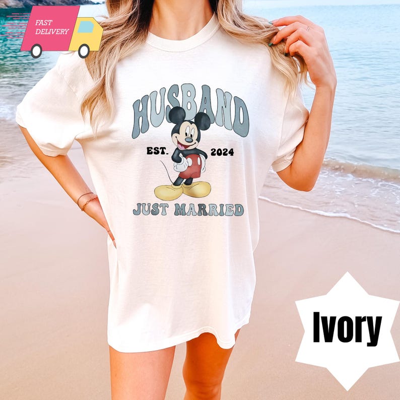 May include: White t-shirt with a graphic of Mickey Mouse and the text "Husband Est. 2024 Just Married".