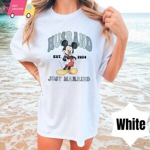 May include: White t-shirt with a graphic of Mickey Mouse and the text "Husband Est. 2024 Just Married".
