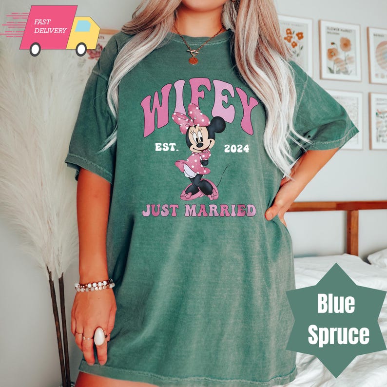 May include: Green t-shirt with a pink and white Mickey Mouse graphic and the text "Wifey Est. 2024 Just Married".