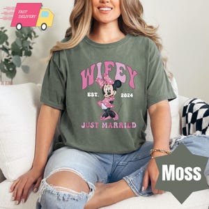 May include: A green t-shirt with the text "WIFEY EST. 2024 JUST MARRIED" and a cartoon image of Minnie Mouse in a pink dress.