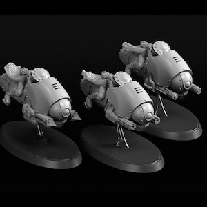 May include: Three grey miniature vehicles with rounded bodies, detailed with rivets and weaponry, mounted on black oval bases. Each vehicle has a central cockpit area and side-mounted guns, suggesting a futuristic or sci-fi theme.