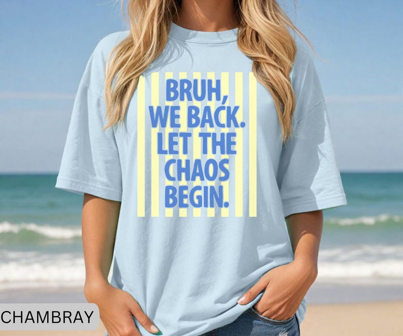 May include: Light blue t-shirt with the text "BRUH, WE BACK. LET THE CHAOS BEGIN." in blue letters on a yellow striped background. The shirt is made of a soft material and has short sleeves.