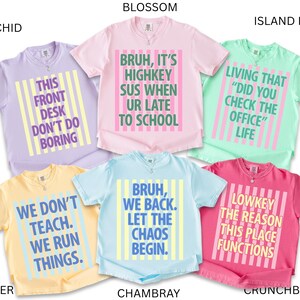May include: Collection of six short-sleeved t-shirts in various colors, each with a unique graphic text design. Colors include orchid, butter, blossom, island reef, chambray, and crunchberry. The shirts feature phrases like "This Front Desk Don't Do Boring" and "Bruh, We Back."