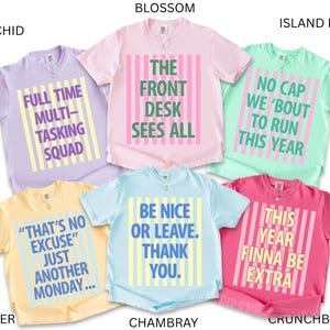 May include: A collection of short-sleeved t-shirts in various colors, each with a unique graphic text design. Colors include orchid, butter, blossom, island reef, chambray, and crunchberry. The text on the shirts includes phrases like "Full Time Multi-Tasking Squad" and "Be Nice or Leave."