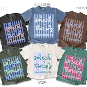 May include: Six short-sleeve crew neck t-shirts in pepper, bluejean, espresso, moss, ivory, and light green. Each shirt features a central graphic with vertical stripes, small star icons, and the text "speech therapy YOUR WORDS MATTER".