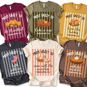May include: Six short-sleeve t-shirts in maroon, olive, mustard, charcoal, cream, and brown, each featuring a vertical striped panel with the text "MOST LIKELY TO" above a unique graphic and "THANKSGIVING 2026" below, including pumpkins, a sofa, turkey, heart, snacks, and pie.