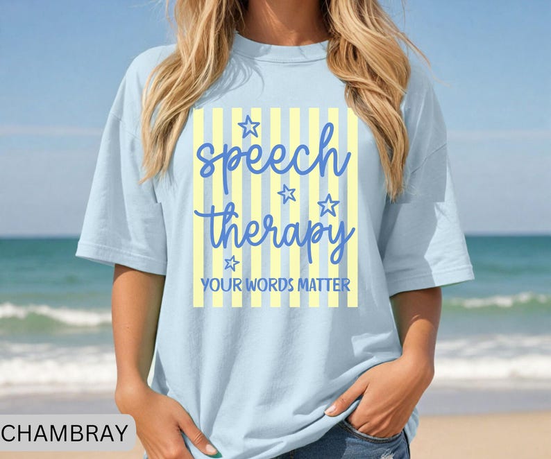 May include: A light blue t-shirt featuring a central graphic with vertical yellow and white stripes. The text reads speech therapy in blue script, accompanied by four blue star outlines and the text YOUR WORDS MATTER in blue block letters.