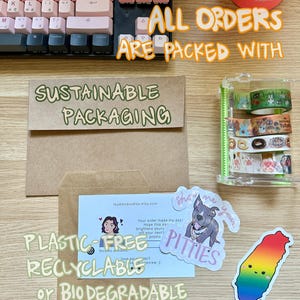 An image of sustainable packaging materials including glassine bags, a paper thank you postcard, and some stickers and washi tape.