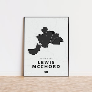 Op de afbeelding: Een zwart-witte kaartprint van Joint Base Lewis-McChord, een militaire basis in de staat Washington. De kaart toont de grenzen van de basis en de omliggende gebieden. De tekst "Joint Base Lewis-McChord" is onder de kaart gedrukt.
