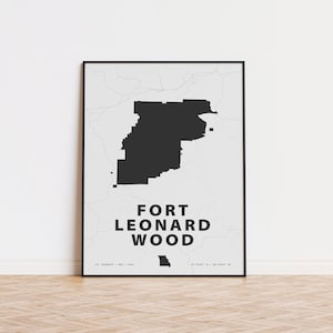 May include: Black and white print of a map of Fort Leonard Wood, Missouri. The map is framed in a black frame and is hanging on a white wall.