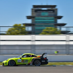 May include: A bright green race car with black accents and the number 27 on the side. The car has the word "Allied" in large letters on the side. The car is on a race track.