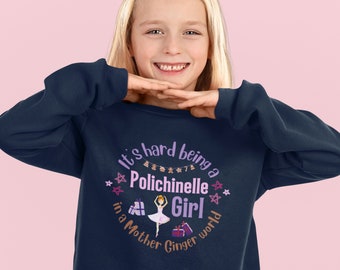 May include: A navy blue sweatshirt with a purple and pink graphic that says "It's hard being a  Polichinelle Girl in a Mother Ginger world". The graphic features a ballerina with a pink tutu and a pink bow in her hair.