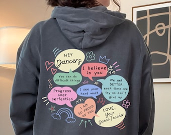 Könnte beinhalten: Ein dunkelgrauer Hoodie mit einer motivierenden Botschaft für Tänzer. Der Text beinhaltet "Hey Dancers", "I believe in you", "Progress over perfection", "I see your hard work", "We get better each time we try so don't give up", "I am so proud of you", und "Love, Your Dance Teacher".