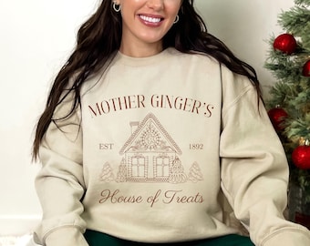 May include: A beige sweatshirt with a brown gingerbread house graphic and the text "Mother Ginger's Est 1892 House of Treats".