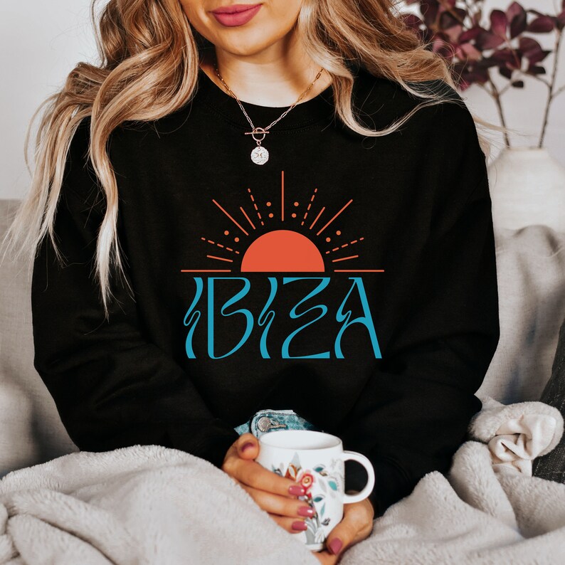 May include: Black sweatshirt featuring a graphic of a red sun with blue rays and the word "IBIZA" in blue lettering.
