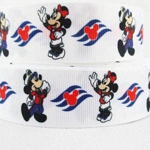 May include: Two rolls of white ribbon featuring a repeating pattern of Mickey and Minnie Mouse characters in red, black, and blue. The ribbon also includes a Mickey Mouse logo.