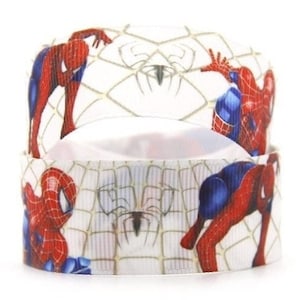May include: White ribbon with a repeating pattern of a red and blue Spiderman character on a white web background.