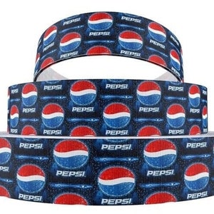 May include: Three rolls of blue and white ribbon with a repeating pattern of the Pepsi logo. The ribbon is printed with the Pepsi logo and the words "Pepsi" in white.