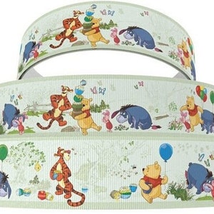 May include: A green and white ribbon with a repeating pattern of Winnie the Pooh and his friends. The characters include Winnie the Pooh, Tigger, Piglet, and Eeyore. The ribbon is decorated with butterflies and balloons.