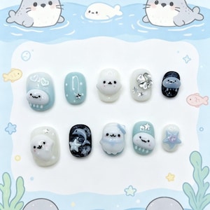 Peut inclure: Un ensemble de dix faux ongles sur le th&egrave;me de la vie marine. Les ongles pr&eacute;sentent divers motifs, notamment des phoques, des &eacute;toiles et des &eacute;l&eacute;ments aquatiques dans des tons de bleu, blanc et noir. Certains ongles ont des ornements en 3D.