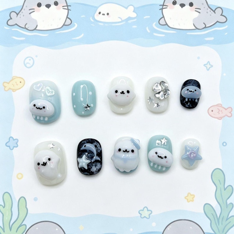 Peut inclure: Un ensemble de dix faux ongles sur le th&egrave;me de la vie marine. Les ongles pr&eacute;sentent divers motifs, notamment des phoques, des &eacute;toiles et des &eacute;l&eacute;ments aquatiques dans des tons de bleu, blanc et noir. Certains ongles ont des ornements en 3D.