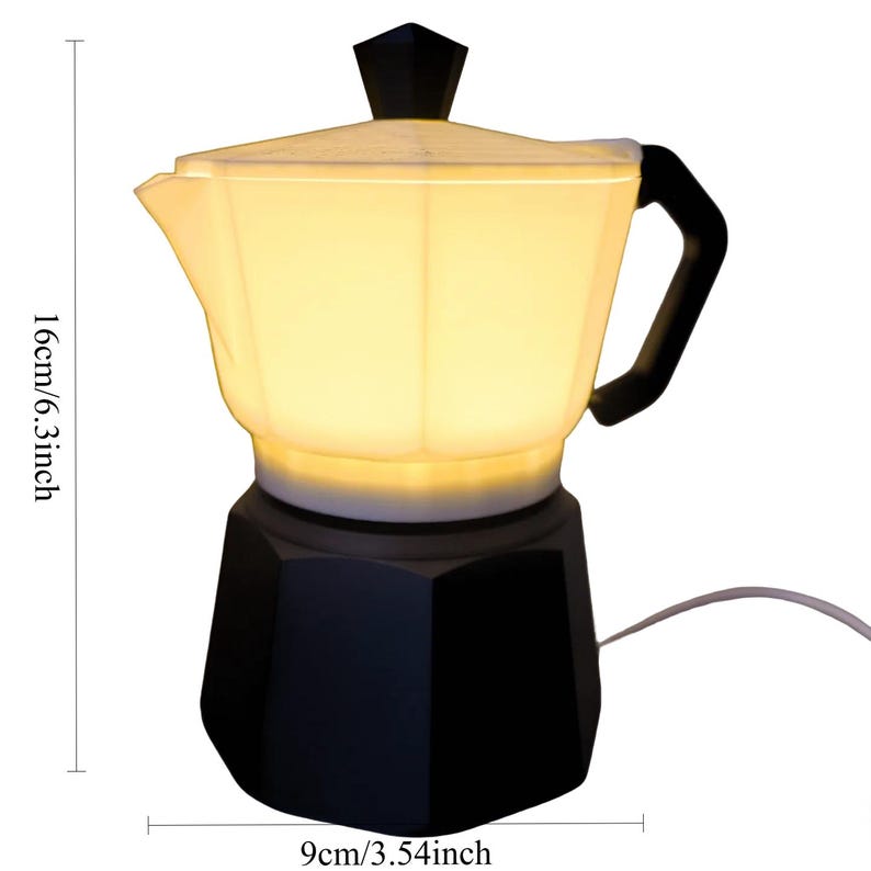 May include: A black and white coffee pot-shaped lamp. The lamp is 6.3 inches tall and 3.54 inches wide. The lamp has a black handle and a black top. The lamp is lit from within, giving off a warm glow.