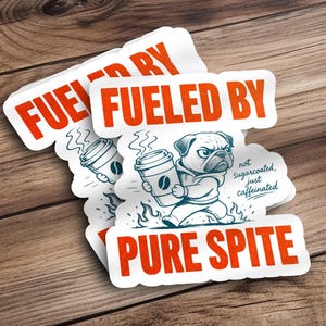 Op de afbeelding: Een gestanste sticker met een cartoon mopshond in een hoodie die een koffiebeker vasthoudt. De tekst luidt FUELED BY PURE SPITE en not Sugarcoated, just caffeinated. Het ontwerp bevat oranje letters en een blauwe illustratie van de hond.