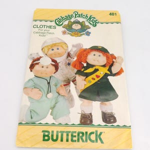 May include: A vintage Butterick pattern for Cabbage Patch Kids clothes. The cover features three dolls dressed as a doctor, an astronaut, and a girl scout. The Cabbage Patch Kids logo is at the top.