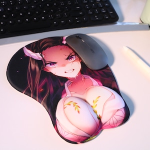 May include: A pink and white anime-style wrist rest with a female character with long black hair and a pink and white outfit. The wrist rest is on a white surface with a computer mouse and a pen.