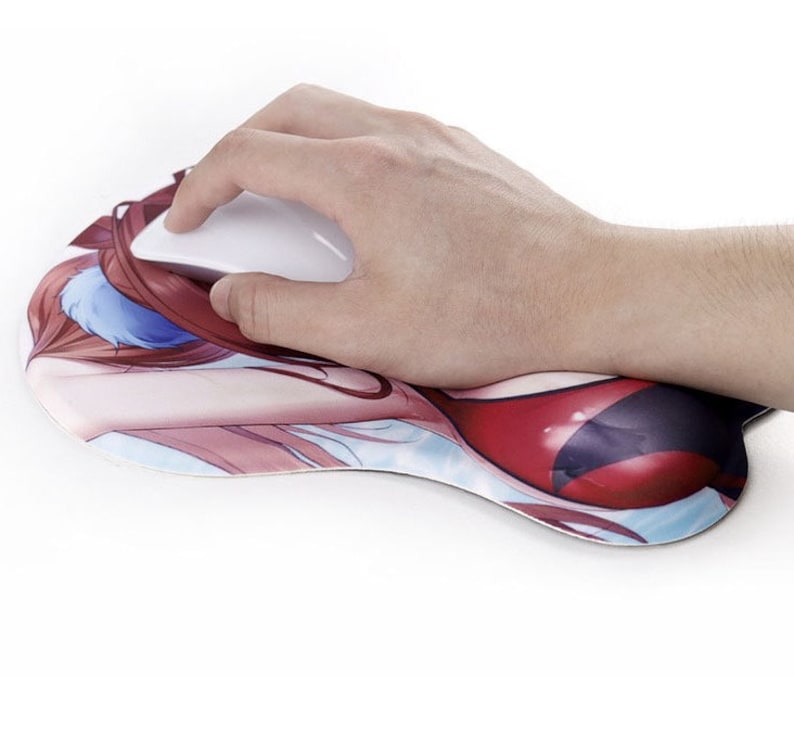 May include: A white computer mouse rests on a custom mousepad with a printed anime-style illustration. The mousepad features a padded wrist rest and a design with red, blue, and skin-tone colors.