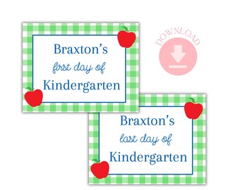 May include: Two square signs with a green and white gingham pattern border. The top sign reads "Braxton's first day of Kindergarten" and the bottom sign reads "Braxton's last day of Kindergarten". Each sign has a red apple graphic.