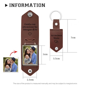 May include: A brown leather keychain featuring a metal frame with a photograph of a couple. The leather is engraved with the text 'Guida con attenzione ho bisogno di te' and 'An meinen Mann' with heart icons. Dimensions are 7cm by 3.5cm and 2.3cm by 3cm.