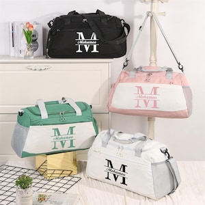 May include: Four duffel bags in black, pink, white, and green, each with a white or matching color panel. The bags have a shoulder strap and handles. Each bag has the name "Mohameo" and the letter "M" printed on the front.