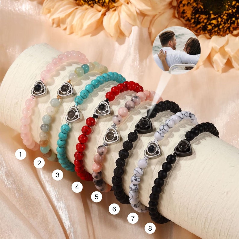 Puede incluir: Ocho pulseras de cuentas diferentes con un dije en forma de coraz&oacute;n que revela una imagen oculta cuando se ve a trav&eacute;s de una lente especial. Las pulseras est&aacute;n hechas con varios colores de cuentas, incluyendo rosa, turquesa, rojo, negro y blanco.