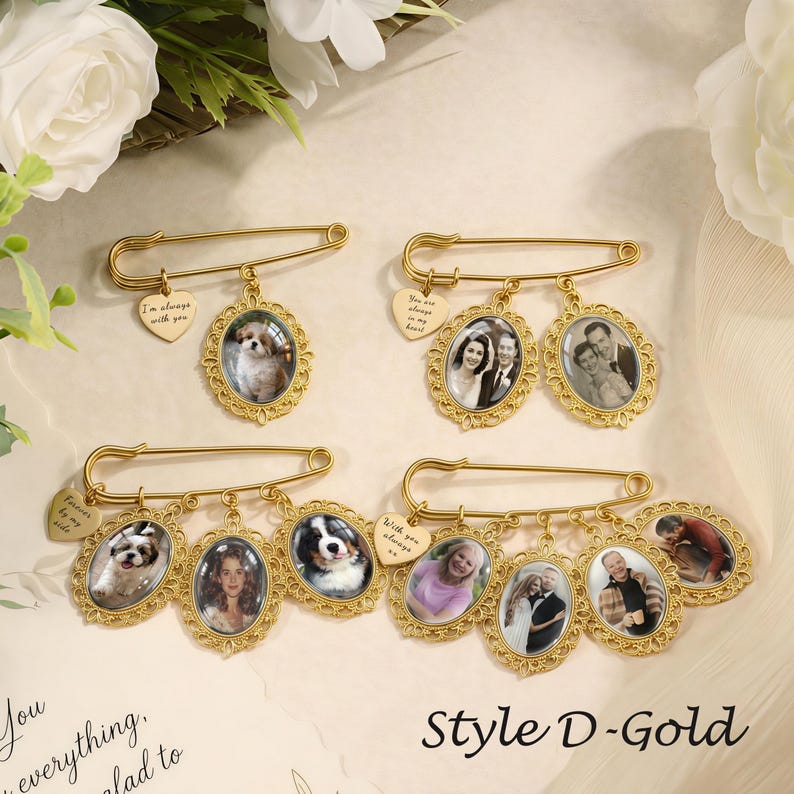 May include: Four gold-toned safety pins featuring oval photo frames with ornate filigree edges. Each pin includes a small heart-shaped charm engraved with text. The pins display various photographs of people and pets, arranged in a decorative display.