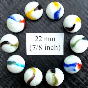 May include: Ten white glass marbles with colourful swirling patterns in blue, red, yellow, green, and brown. The marbles are 22 mm (7/8 inch) in diameter, as indicated by the text in the center.