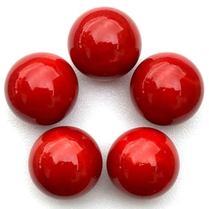 May include: Five glossy, round, red beads arranged in a circular pattern. The beads have a smooth, reflective surface, and the color is a vibrant, solid red. The beads are likely used for jewelry making or crafting.