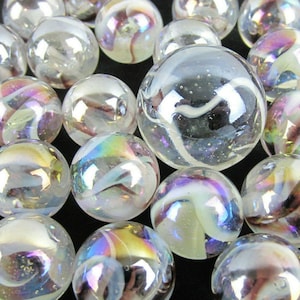 May include: A collection of clear glass marbles with iridescent swirls of color. The marbles vary in size and have a reflective, glossy surface. The colors include white, purple, blue, and yellow, creating a rainbow effect.